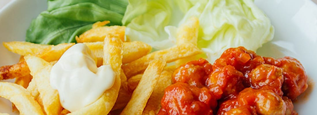Verse frieten met mayonaise, balletjes in tomatensaus en sla