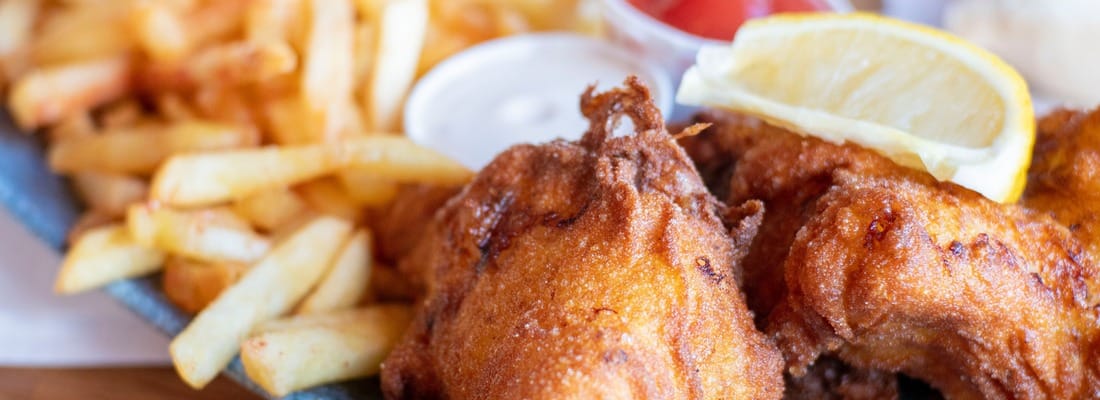 Krokant gebakken kipstukken met verse frieten, saus en een partje citroen